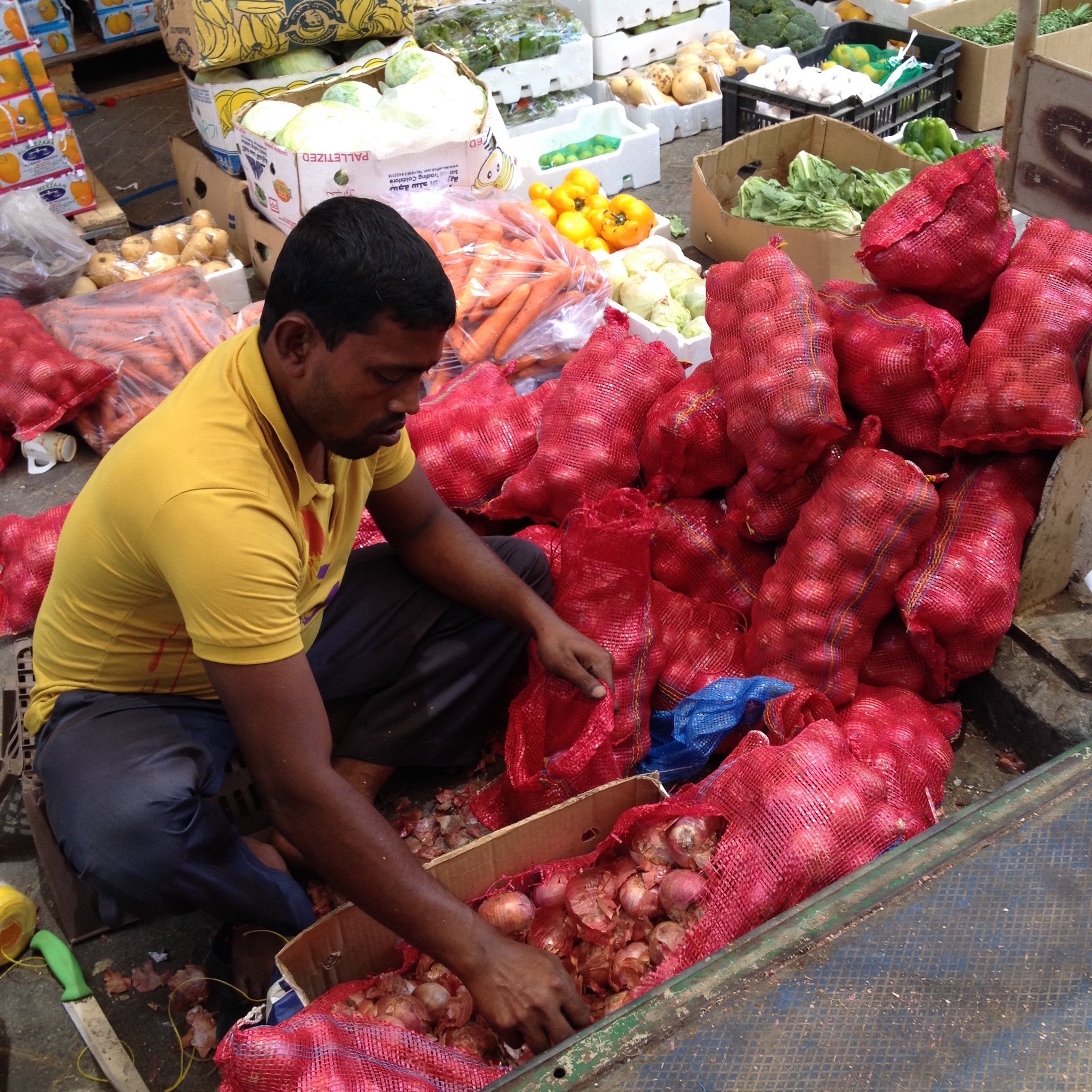 This vendor is cleaning sacks of onions to have them ready for sale. 